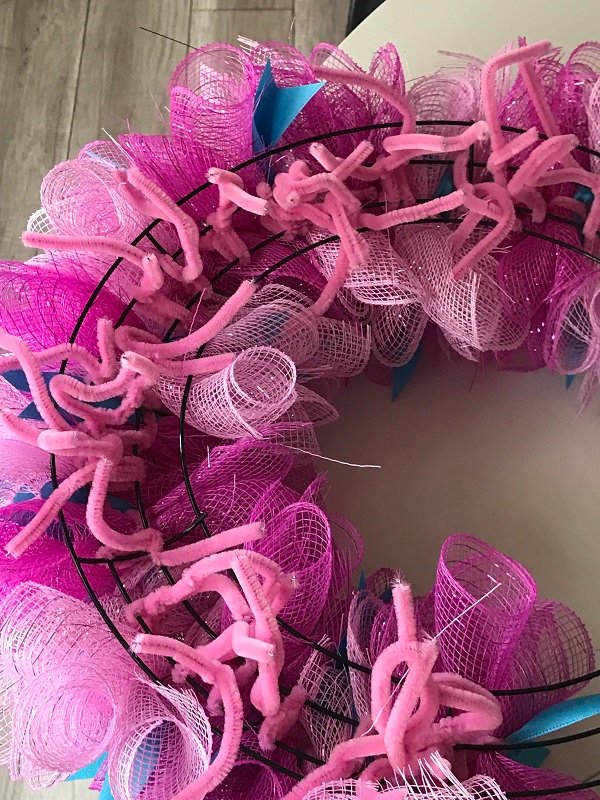 How Do You Make A Spiral Wreath Out of Mesh | the backside of the wreath after chenille stems have been added to secure the mesh to the wreath frame. 