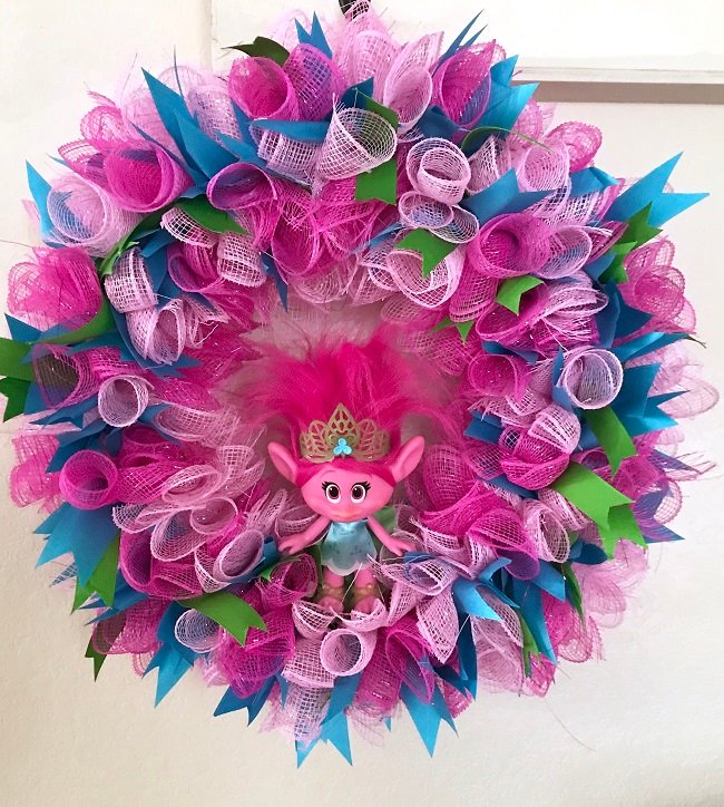 How to Make A 6 Inch Deco Mesh Wreath, Step by Step With Pictures | A DreamWorks Trolls inspired 6 inch deco mesh wreath made using light and dark pink deco mesh, and green & blue ribbon, with a Poppy doll as the centerpiece. 